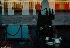 reflecting in the windows of the Copenhagen Royal Theater, someone drinking coffee, not paying attention to the beautiful sunset, photographs in the restaurant give an interesting interplay with forms and colors