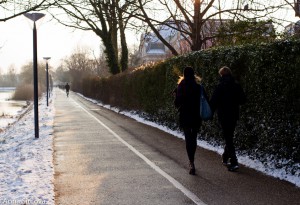 a couple walks hand in hand by the lakes in Copenhagen in the afternoon light