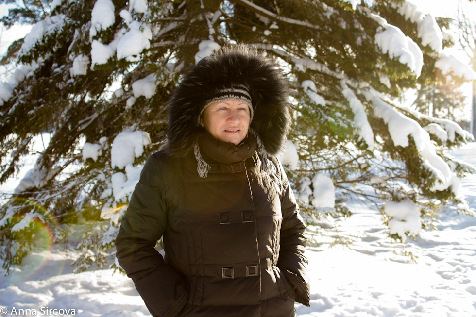 my mom next to a big pine tree, covered with snow, Umea, Sweden